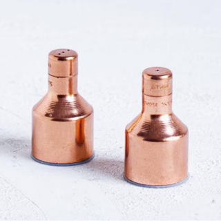 A set of two copper salt and pepper shakers with a polished finish on a white background.