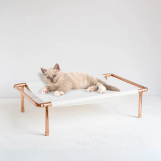 Handmade copper frame cat hammock bed with a durable canvas sling, elevated design, and minimalist style. Perfect for cats and small dogs as a comfortable and chic lounging space.
